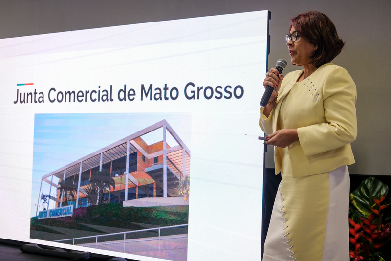 Presidente Gercimira Rezende fazendo uma apresentação. Ao fundo, projeção de um dos slides de sua apresentação.